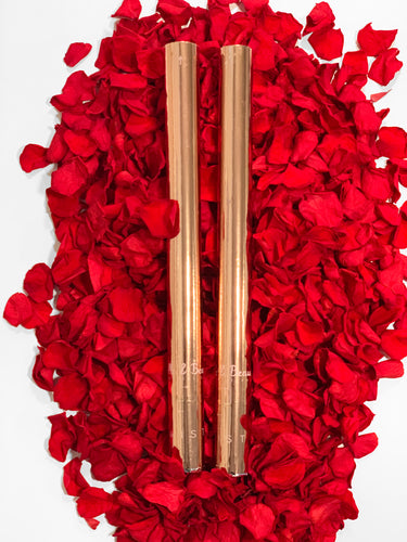 Two Rose Petal Cannons sitting on a bed of red rose petals